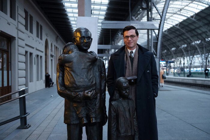 One Life - Wer ein Leben rettet, rettet die ganze Welt: Schauspieler Johnny Flynn in seiner Rolle als Nicholas Winton neben dem Denkmal f&uuml;r Nicholas Winton am Prager Hauptbahnhof. Bild: Sender /  ZDF / JULIE VRABELOVA. 