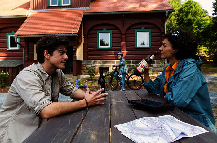 Vor der Rangerstation tauschen sich Ranger Jonas (Philipp Danne) und Biologin Emilia (Lisa Tzschirner) über eine m&ouml;gliche Zukunft der W&ouml;lfe im Nationalpark aus. Bild: Sender / MDR / ndF / Tom Schulze