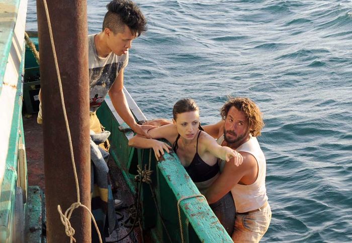 Eva &uuml;ber Bord: Der Schmuggler Nik (Stephan Luca) und sein stummer Partner Rio (Charlie Ruedpokanon) fischen die tollpatschige Journalistin aus dem Wasser. Bild: Sender / Thanaporn Arkmanon
