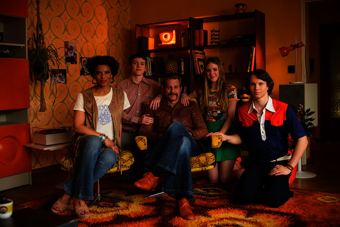 Grüße aus 1976 - Auf Zeitreise mit Thomas Heinze": Familie Heinze mit Jackie Brown, Lennon, Thomas Heinze, Lucille und Sam sitzen in einem typischen Wohnzimmer des Jahres 1976. Bild: Sender / ZDF / Martin Valentin Menke.