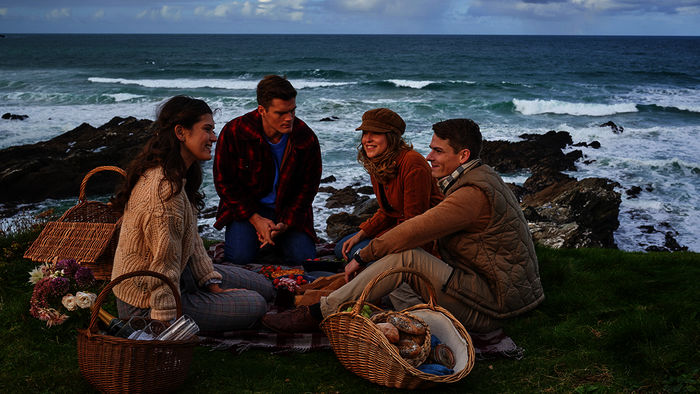 Abigail (Caroline Hartig) und ihre Schwester Doreen Collins (Leonie Brill) lernen Mo Miller (Paul Triller), den Kameraden und Freund von Bill Pexton (Marvin Linke) bei einem gemeinsamen Picknick an der K&uuml;ste kennen. Doch Abigail und Mo kennen sich bereits, was sie den anderen jedoch verschweigen. Bild: Sender /  ZDF / Jon Ailes. 