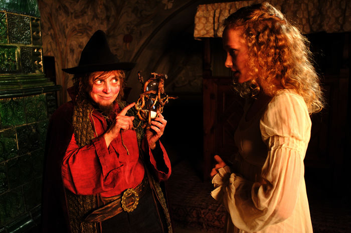 Das Rumpelstilzchen (Katharina Thalbach) h&auml;lt eine Sanduhr in der Hand und zeigt diese der jungen K&ouml;nigin Marie (Marie-Christine Friedrich). Bild: Sender/ ZDF /Christian Schneider